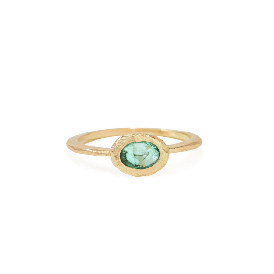 Oval Emerald set in 18 karat yellow gold oval on a thin gold band