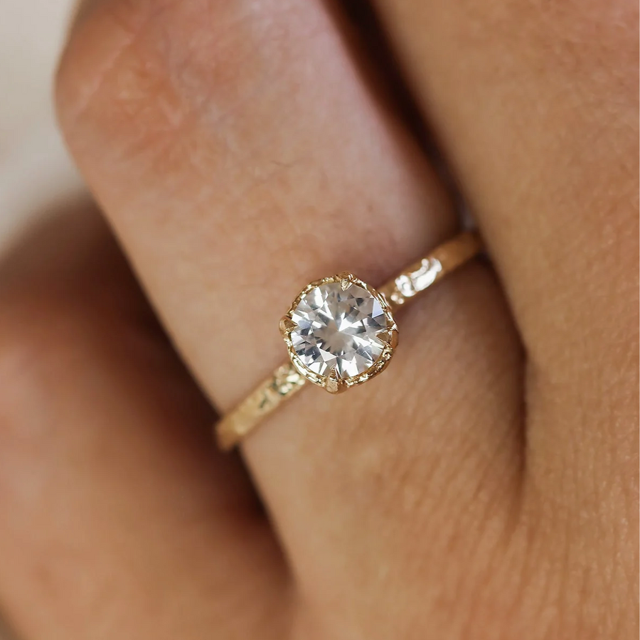Gold ring with a diamond on a finger