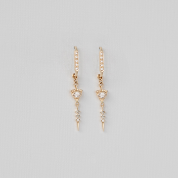 Gold earrings with small gemstones on a light gray background