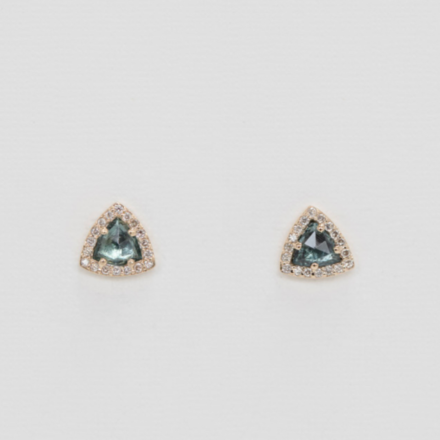 Pair of trapezoid-shaped earrings with green blue gemstones on a light gray background