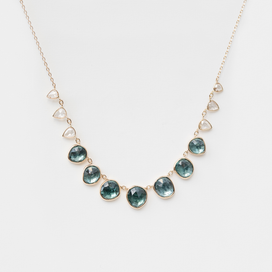 Necklace with green gemstones and diamonds on a white background