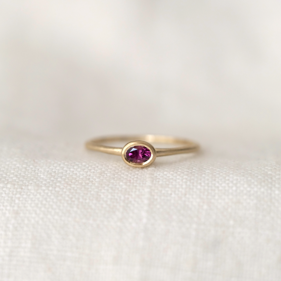 oval grape garnet bezel set in 14k gold on thin gold band