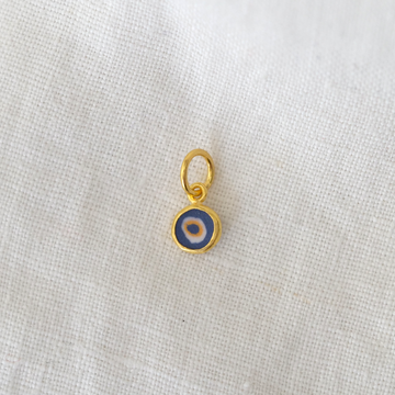Gold pendant with a blue and white center on a light gray background