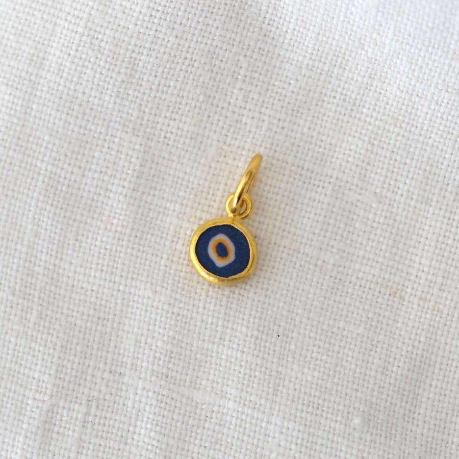 Gold pendant with a blue center on a light gray background