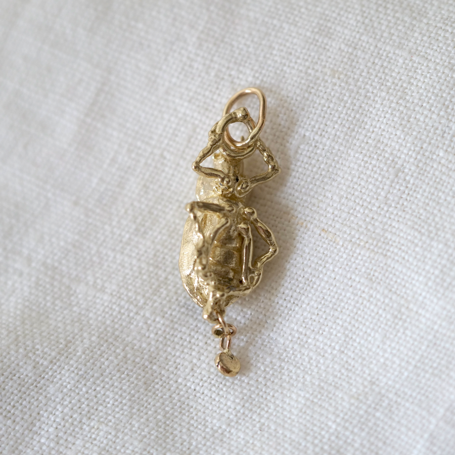 Gold pendant on a white fabric background