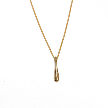Gold necklace with a teardrop pendant on a white background