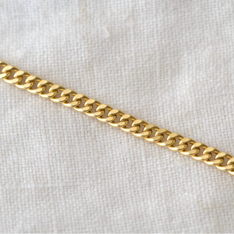 Gold chain on a light gray background