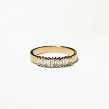 Gold ring with baguette-cut diamonds on a white background