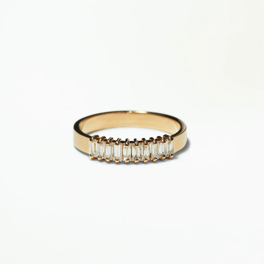 Gold ring with baguette-cut diamonds on a white background