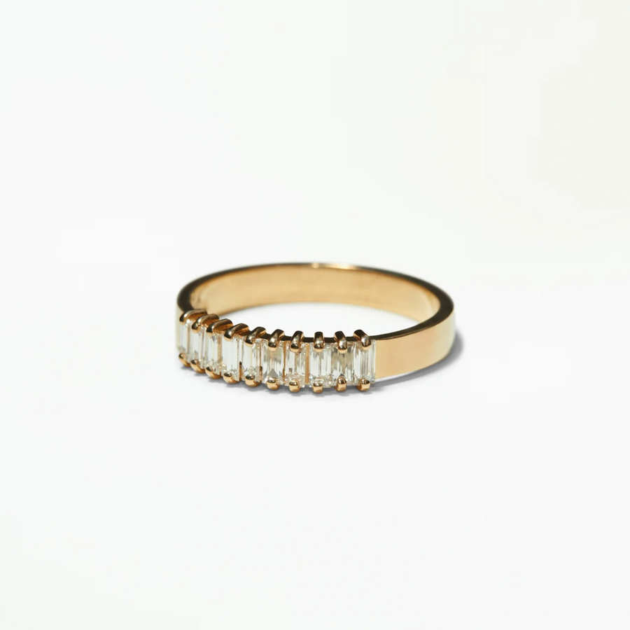 Gold ring with baguette-cut diamonds on a white background