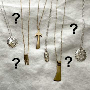 Collection of necklaces with unique pendants on a textured surface