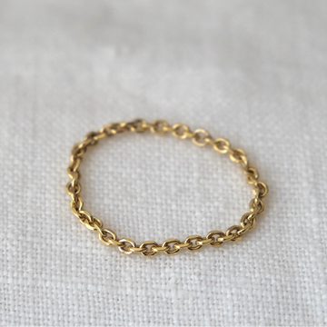 Gold chain ring on a light gray background