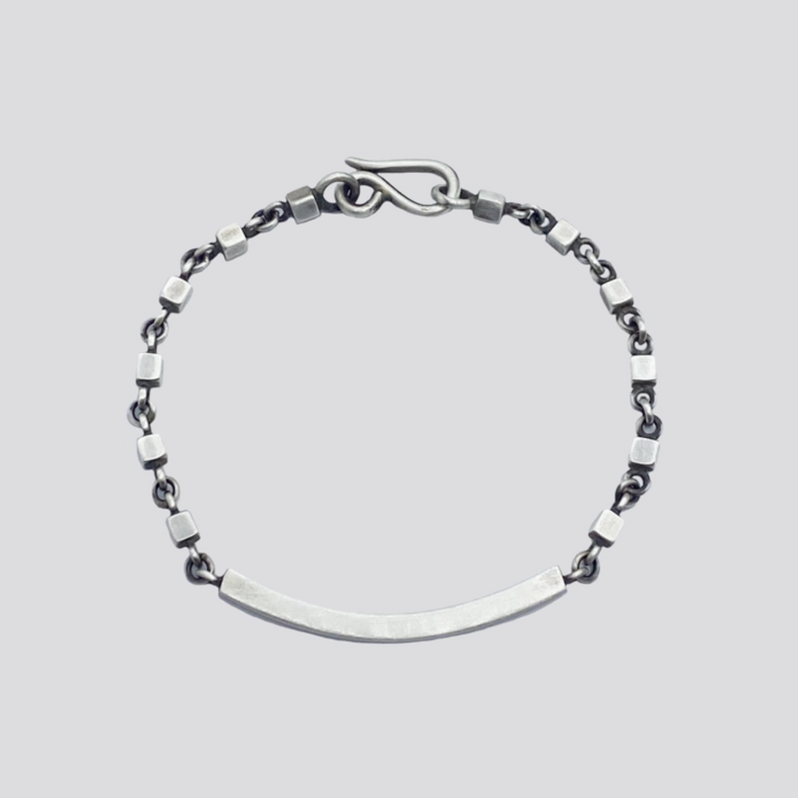 Silver bracelet with a bar clasp on a light gray background