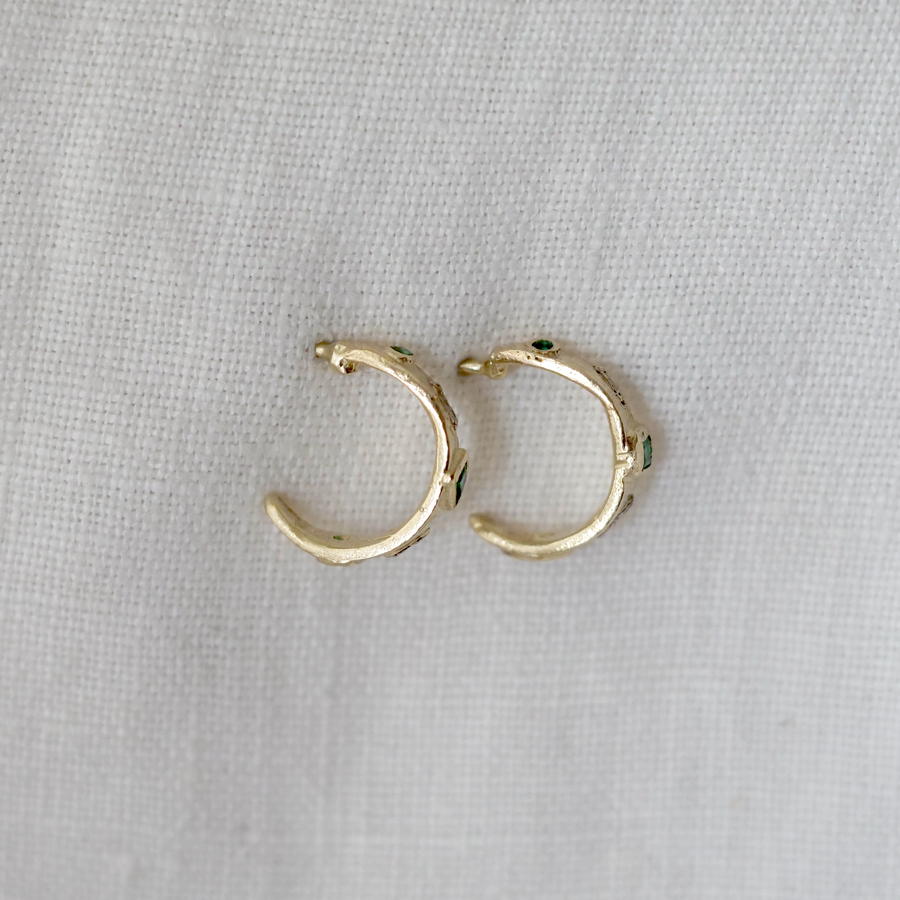 Gold hoop earrings on a light gray background