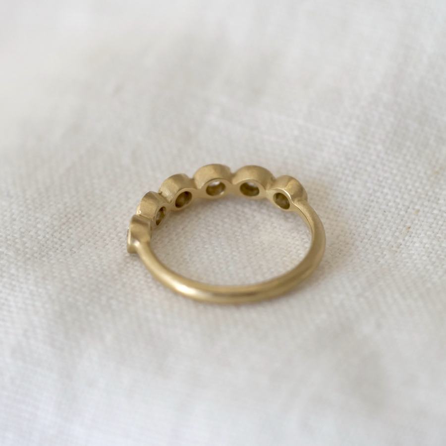 Gold ring with small stones on a white fabric background