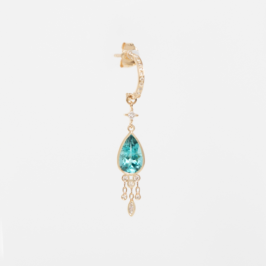 Gold earring with a blue gemstone on a white background