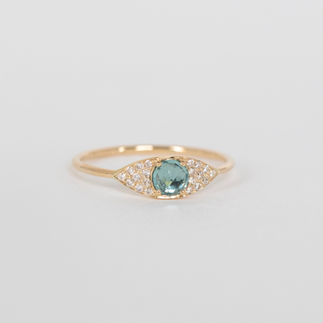 Gold ring with a blue gemstone on a light gray background
