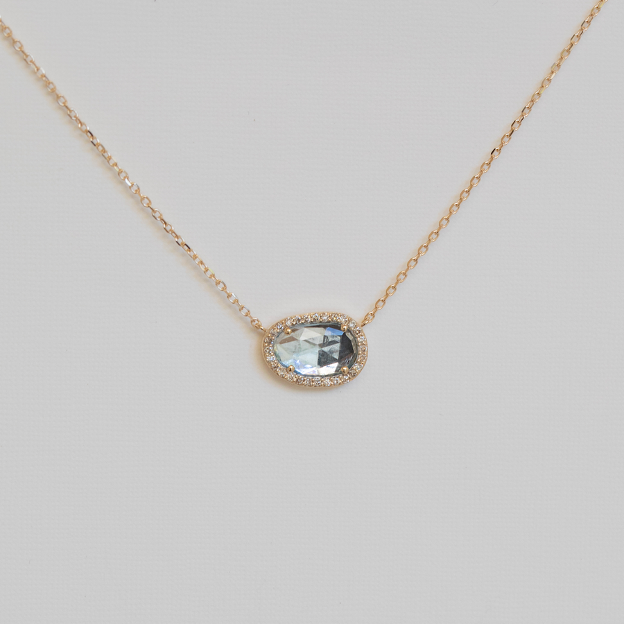 Necklace with a pendant featuring a blue gemstone on a light gray background