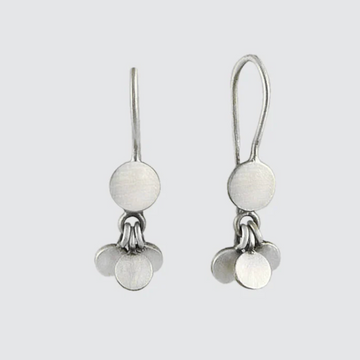 Pair of silver earrings with round white stones on a light gray background