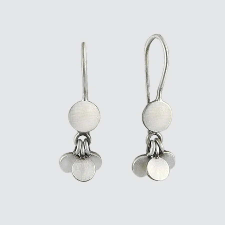 Pair of silver earrings with round white stones on a light gray background