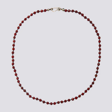 Red beaded necklace on a light gray background