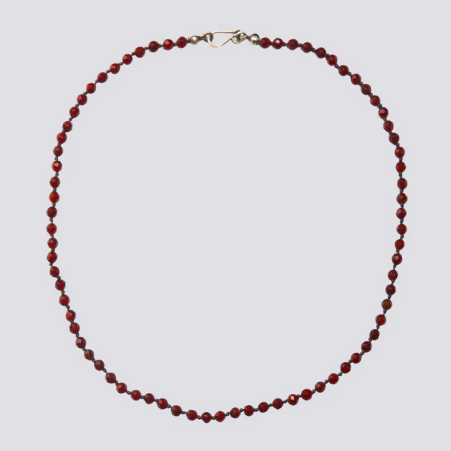 Red beaded necklace on a light gray background