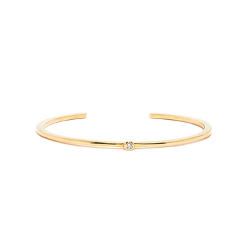 Gold bracelet with a small diamond on a white background