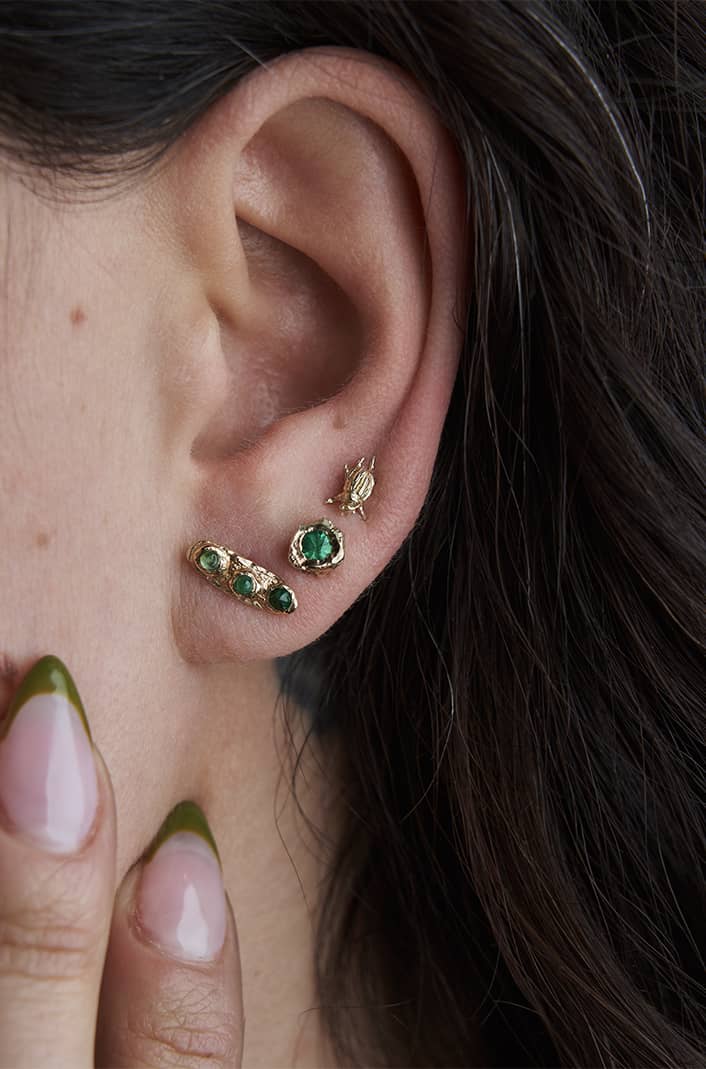 A pair of the ittiest bittiest hand sculpted beetles rest perfectly on your ears, shown on model 