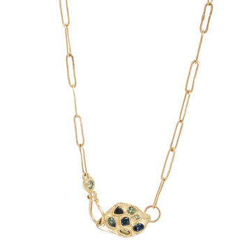 Gold necklace set with green tourmaline, with a decorative clasp on a white background