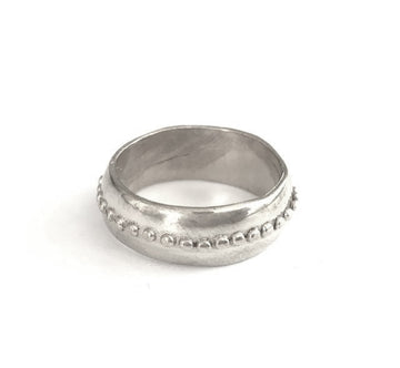 Silver ring with textured band on a white background
