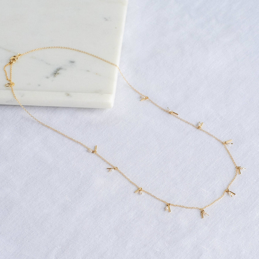 delicate gold chain with gold fringe and pearls evenly spaced along the chain