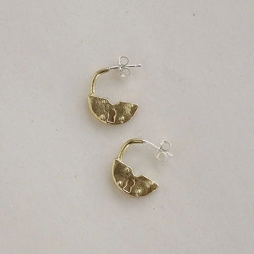 Gold hoop earrings on a light gray background
