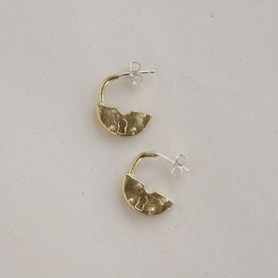 Gold hoop earrings on a light gray background