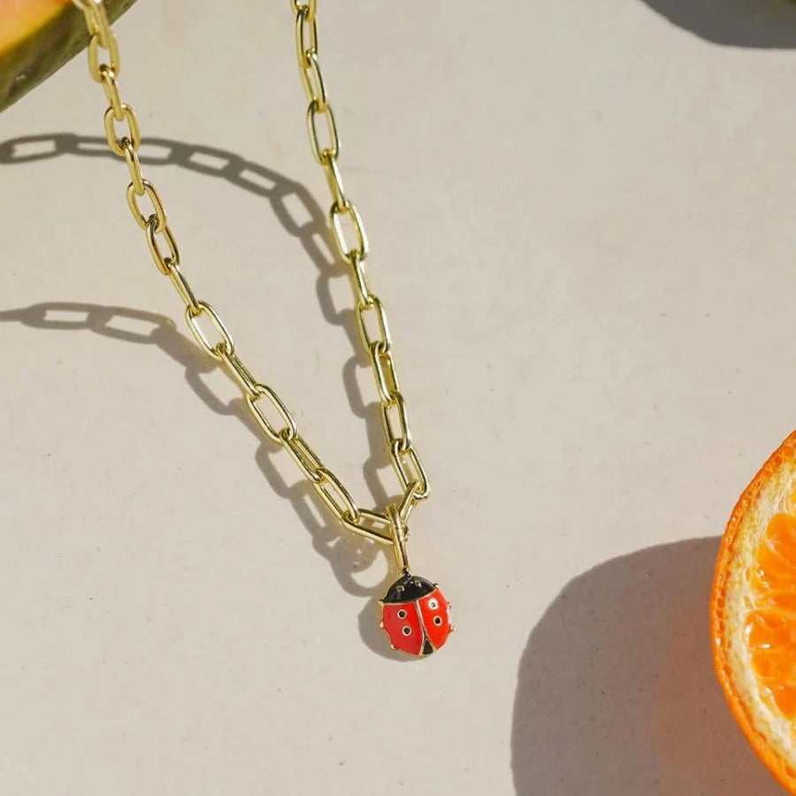 Small round brass lady bug, painted red and black with enamel 