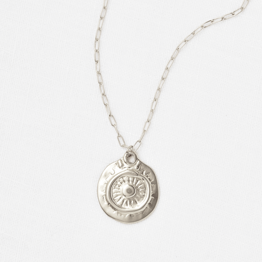 A Rebirth Medallion Necklace by Marisa Mason Jewelry, with a sunburst design, displayed on a plain white background and featuring a paperclip-style chain.