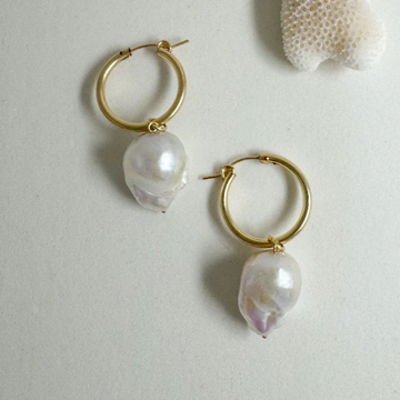 two large, organically shaped pearls hang from thick gold filled hoops 