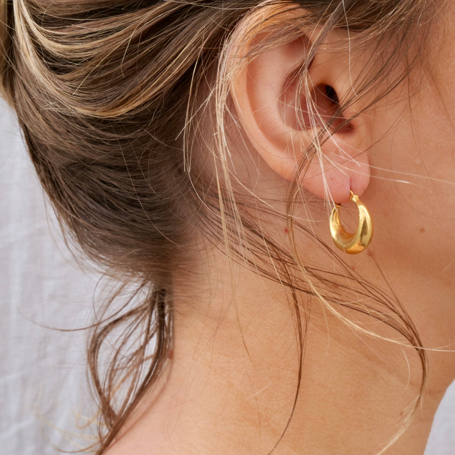 Hollow 18k Indian gold hoops on model 