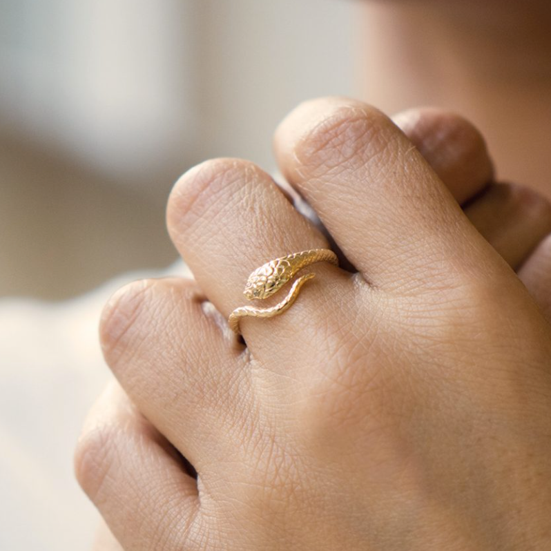 Gold Cobra Ring wraps around the finger, with the end of the tail meeting the head with its two white diamonds as eye. 