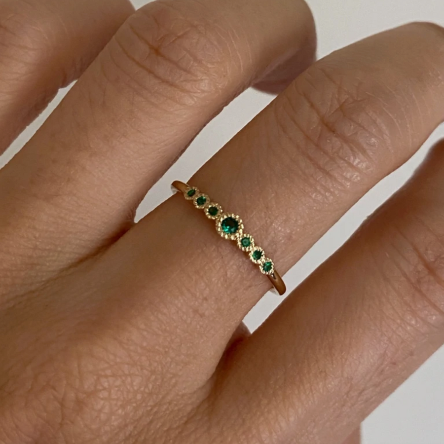 Jennie Kwon Designs round emeralds set in 14k gold seven emeralds engagement ring