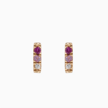 Three pink sapphires - ranging from dark pink, to light pink, to white - set in a 14k gold bar