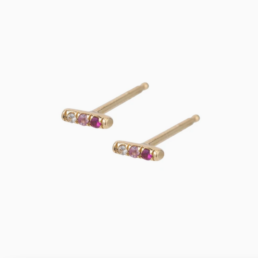 Three pink sapphires - ranging from dark pink, to light pink, to white - set in a 14k gold bar