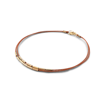 Double-stranded silk cord bracelet with short gold-filled tubes that shift freely.