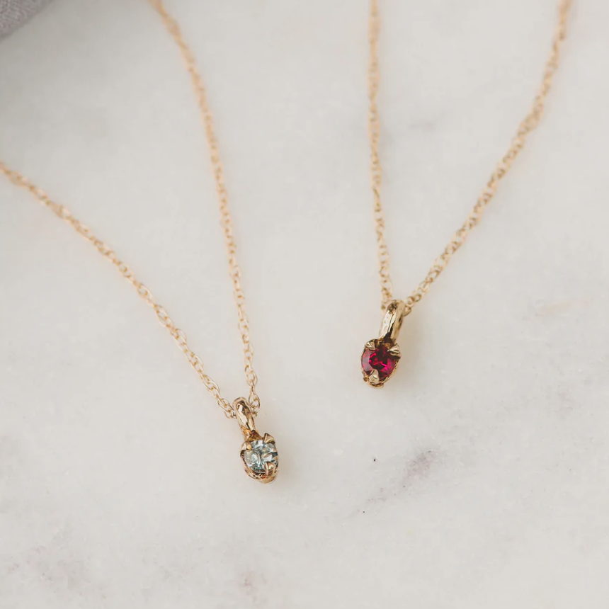 14k Gold Dainty Birthstone Necklace, two on marble background - white diamond and ruby. 